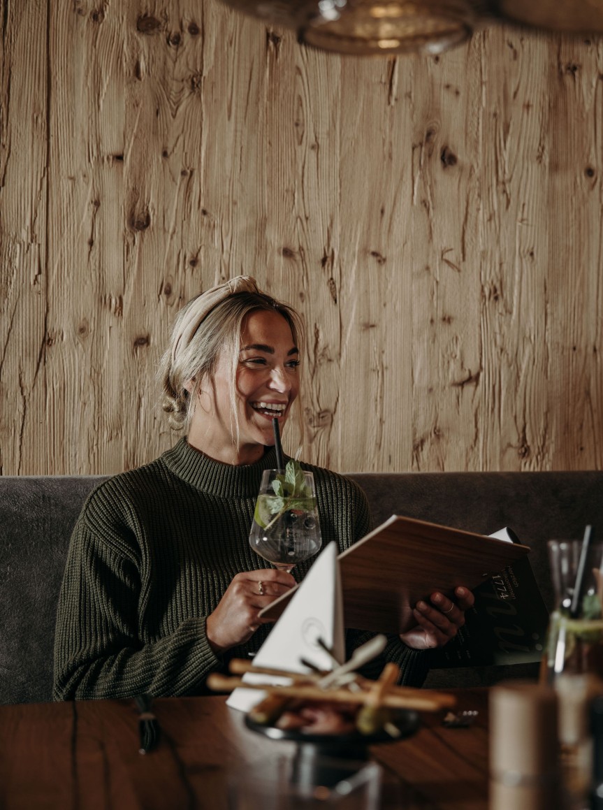 Frau genießt ihren Drink beim Abendessen
